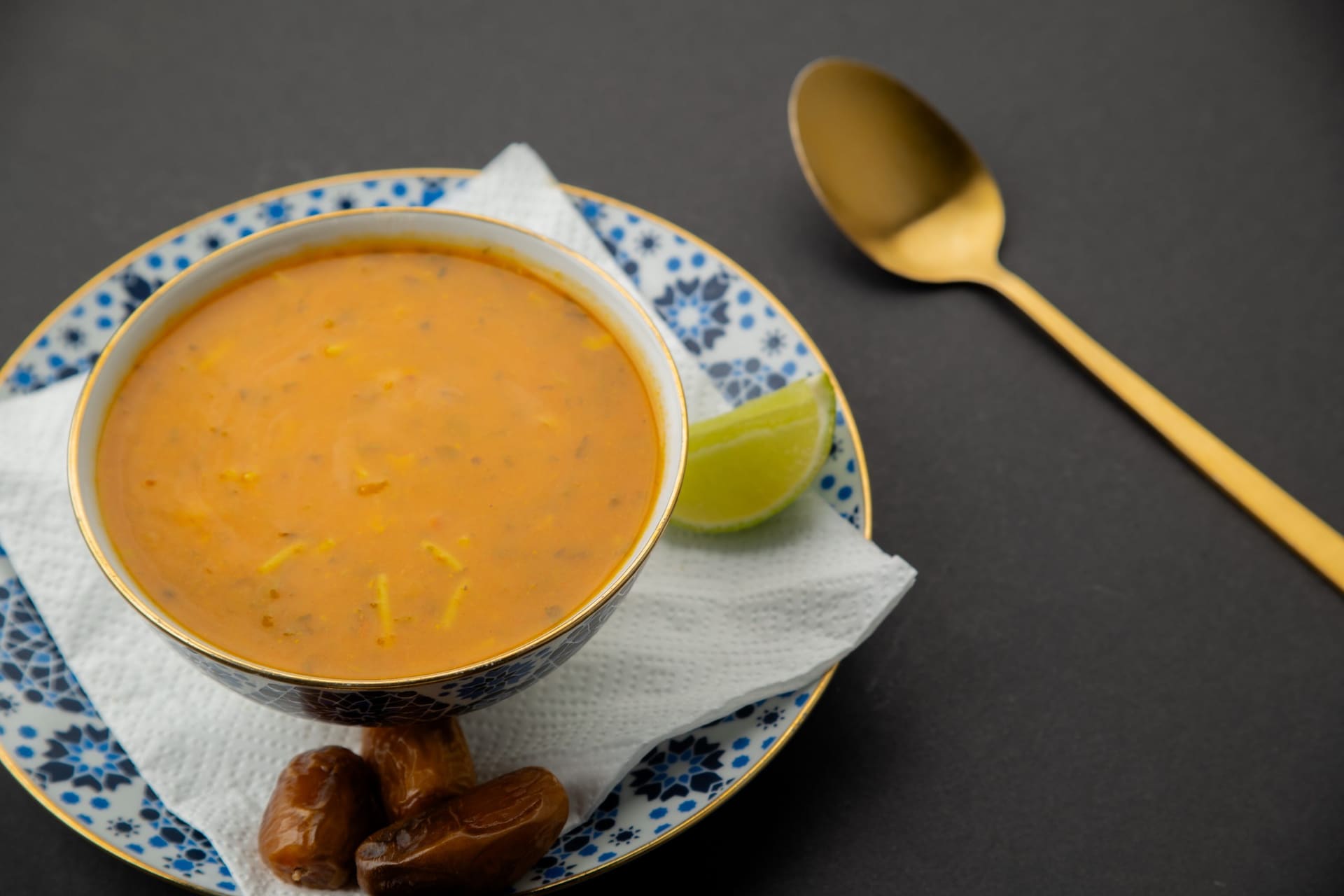 Kom Marokkaanse soep met limoen en dadels op blauw met wit servies