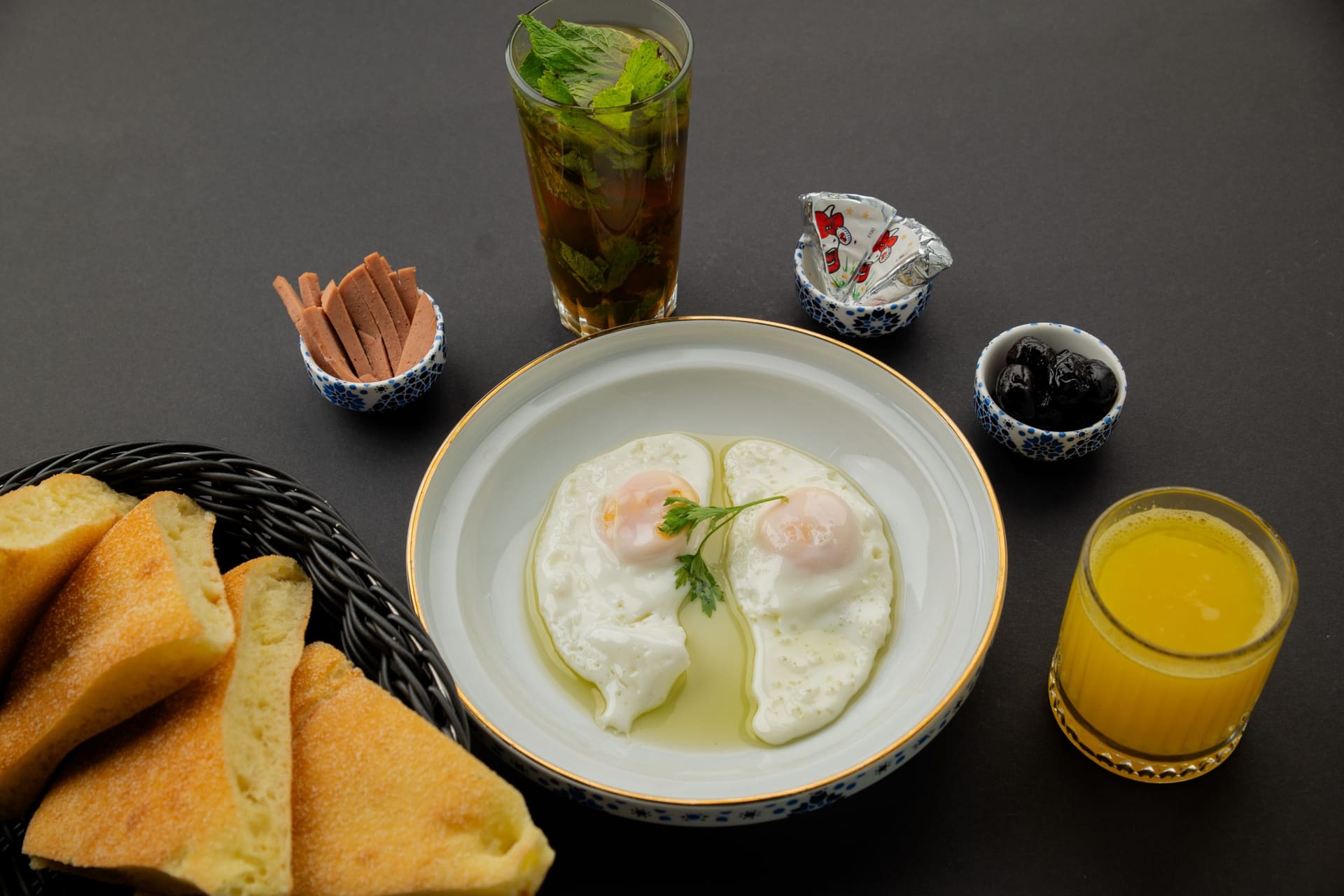 Marokkaans ontbijt met spiegeleieren, muntthee, olijven, brood en verse jus